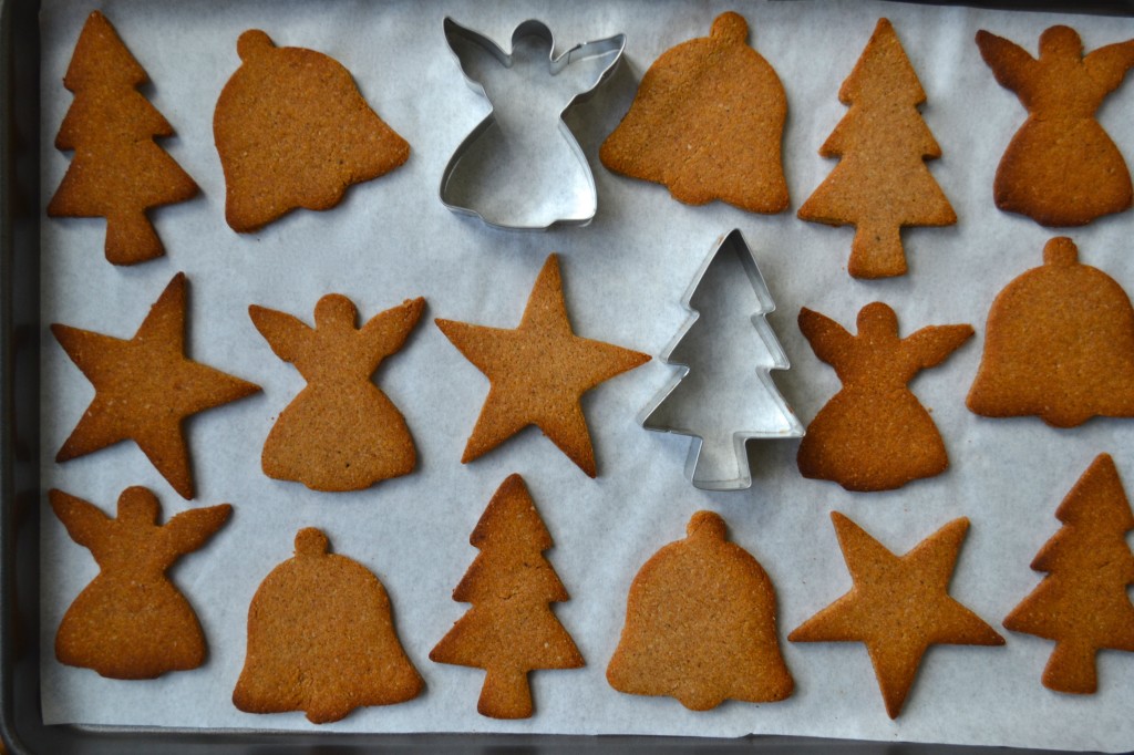 Image shows a tray of cut out cookies with angel, bell and tree shapes